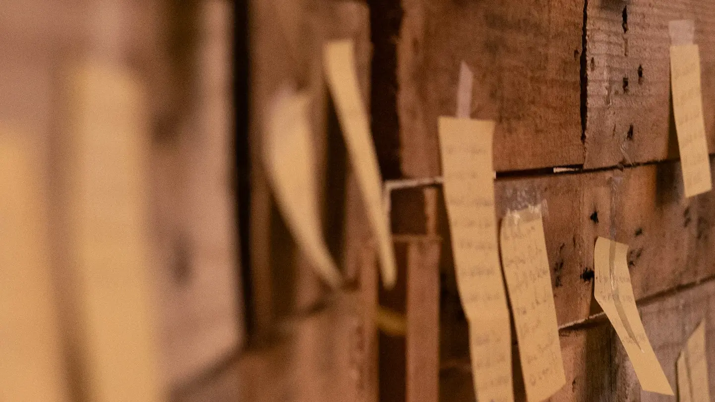 a wooden wall with post it notes attached to it